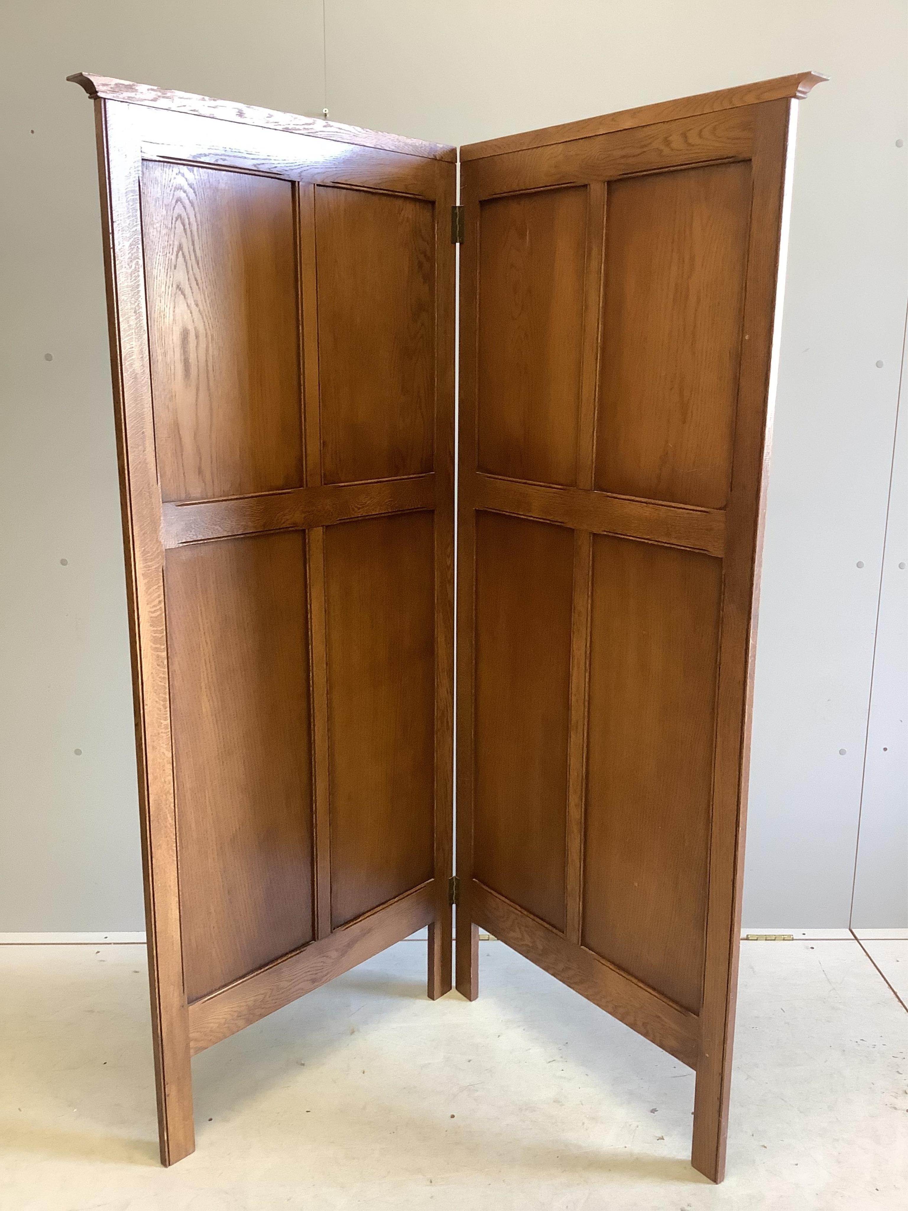 An early 20th century carved oak linen fold two fold dressing screen, each panel width 73cm, height 170cm. Condition - good